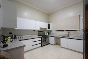 Modern white kitchen at Villa Garnet with oven and storage cabinets