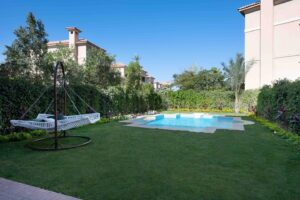 Private pool surrounded by a garden lawn, villa in New Cairo