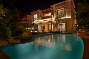 Villa Dora villa with pool and hot tub shown at night in Cairo